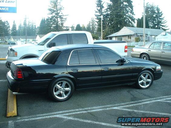 Black sedan parked next to a white pickup truck and a tan sedan