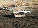 1978 Ford Bronco - Multiple vehicles are stuck in thick mud during an off-road event.