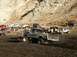 1978 Ford Bronco - Several off-road vehicles are gathered in a muddy area, with one truck prominently featured in the foreground.
