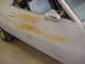 1973 Ford Ranchero - Driver's side door of a 1973 Ford Ranchero, showing primer and rust damage.