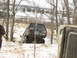 1979 Ford Bronco - A dark SUV is stuck in the snow, with another vehicle partially visible in the foreground.