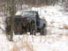 1979 Ford Bronco - A lifted blue pickup truck navigates a snowy, wooded area during winter.