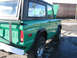 1975 Ford Bronco - This green Ford Bronco is shown from the rear quarter with its hood open, revealing a sign in the window.