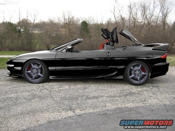 Black 1995 Ford Probe convertible side view with top partially raised