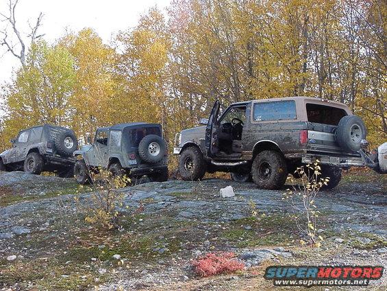 1994 Ford Bronco, 3q-front view, parked on rocks with other off-road vehicles