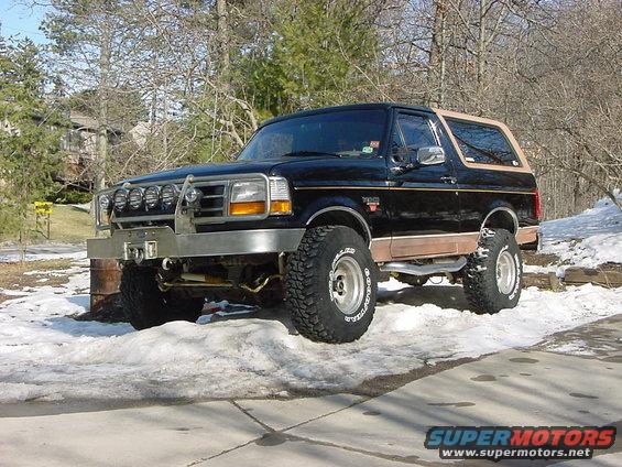 Black Ford Bronco with tan trim and aftermarket bumper, parked in snow