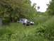 1994 Ford Bronco - Two people are working on the front of a 1978 Ford Bronco parked in tall grass.