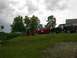 1994 Ford Bronco - A black 1994 Ford Bronco with a brown top is parked next to a red truck on a grassy hill.