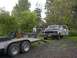 1994 Ford Bronco - A person works on an old pickup truck with its hood open, while a trailer sits nearby.