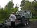 1994 Ford Bronco - Two men load a weathered pickup truck onto a trailer with a winch.