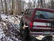 1991 Ford Bronco - 1991 Ford Bronco navigates a snowy, wooded path with its tires on the incline.