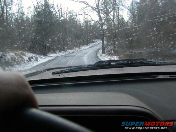 Interior view of a car driving on a wet, snowy road