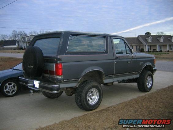 1989 Ford Bronco parked on driveway, rear view with spare tire mounted