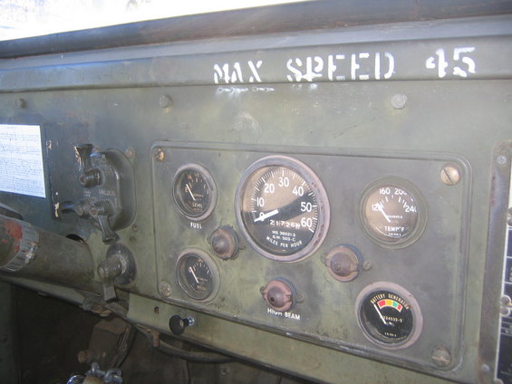 Dashboard gauges and controls in a military truck, with 'MAX SPEED 45' stenciled above