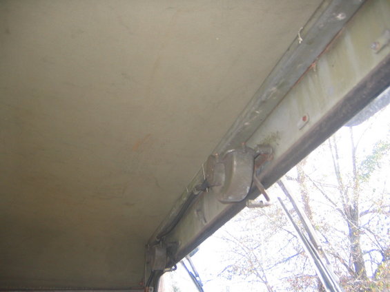 Interior view of a vehicle's roof and window frame with visible latches and hardware