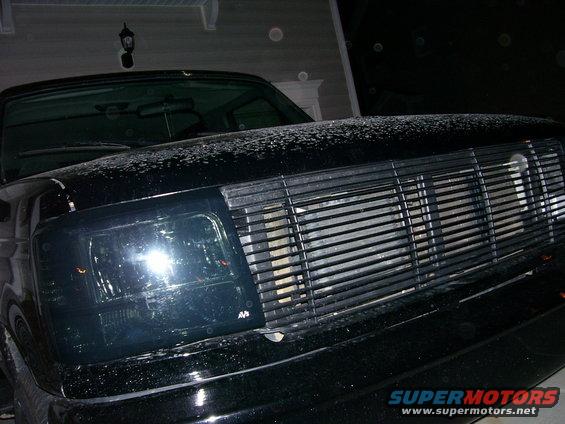 Black Ford Bronco front end with aftermarket grille and smoked headlights. Hood has some white residue