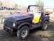 1979 Ford Bronco - This Suzuki Samurai is missing its doors and top, revealing its interior and yellow seats.