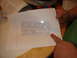 1989 Ford Escort - A document with embossed text is shown, with a finger pointing to it.