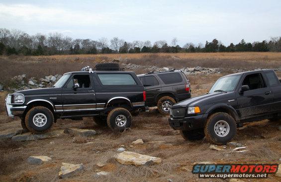 Black 1995 Ford Bronco on rocky terrain with two other vehicles