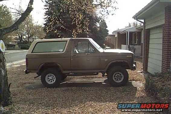 1980 Ford Bronco parked in a driveway next to a house