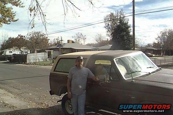Brown 1978 Ford Bronco with a man standing by the driver's door, seen from the front-right