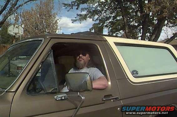 Man with beard and sunglasses in a brown Ford Bronco