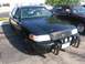 1999 Ford Crown Victoria - A black police car with a push bar and spotlights is parked on asphalt.