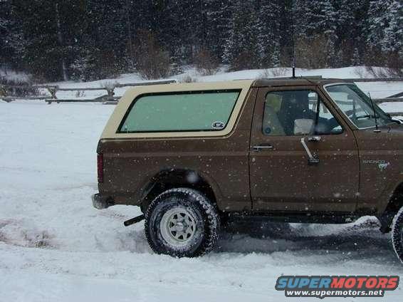 Brown 1980 Ford Bronco side view in snow