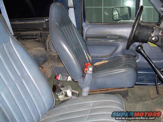 1992 Ford Bronco interior with worn blue seats, floor shifter, and steering wheel