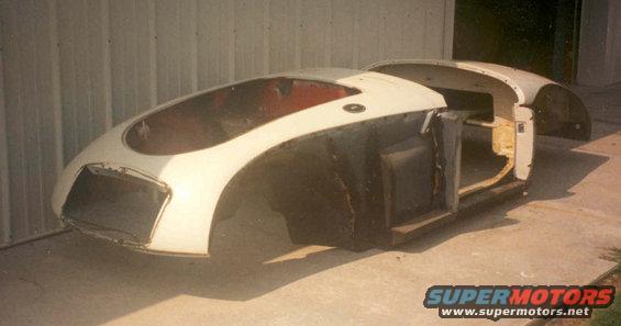 White 1959 MG A body, incomplete, viewed from front-right, showing exposed interior and unfinished panels
