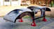 1959 MG A - The body of a car is disassembled and supported by jack stands in a yard.