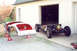 1959 MG A - A car body and its chassis are disassembled in front of a garage, suggesting a restoration project.