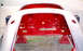 1959 MG A - The rear body shell of a 1959 MG A, painted red inside and white outside, is shown on stands.