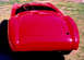 1959 MG A - Rear view of a red 1959 MG A sports car, showing its distinctive rounded trunk and fenders.