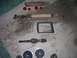 1991 Ford Bronco - Collection of parts for a 1991 Ford Bronco, including the emblem, driveshaft, and speakers.