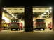 1989 Ford Bronco - Two fire trucks are parked side-by-side in a fire station, with their garage doors open.