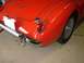 1959 MG A - Rear view of a red 1959 MG A sports car, showing its distinctive tail light and chrome bumper.