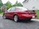 1998 Ford Taurus - This red sedan has a spoiler and a license plate that reads 'ARTSHO'.