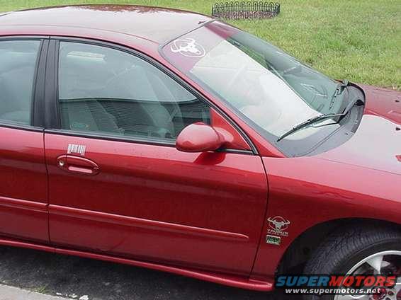 Red 1998 Ford Taurus with a badge on the fender