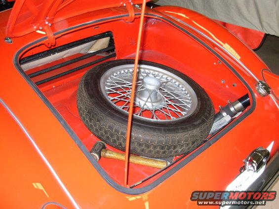 1959 MG A trunk with spare wire wheel, hammer, and jack handle