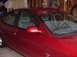 1998 Ford Taurus - The side profile of a red sedan is visible, parked indoors with a glimpse of the interior.