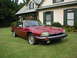 1992 Jaguar XJ-S - A red 1992 Jaguar XJ-S coupe sits on a manicured lawn in front of a suburban home.