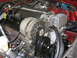 1992 Jaguar XJ-S - Close-up view of an engine bay, a CORVETTE branded valve cover and associated engine components.