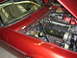 1992 Jaguar XJ-S - Engine compartment of a red car, showing a V8 engine, alternator, and various hoses and wiring.