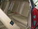 1992 Jaguar XJ-S - The interior of a car shows the rear seating area with tan leather upholstery and red seatbelts.