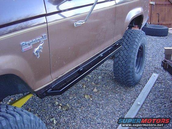 Brown 1986 Ford Bronco II side view with aftermarket side steps and large tires