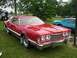 1976 Ford Thunderbird - A red 1977 Ford Thunderbird coupe is seen from a three-quarter front angle, parked outdoors with another vehicle in the background.