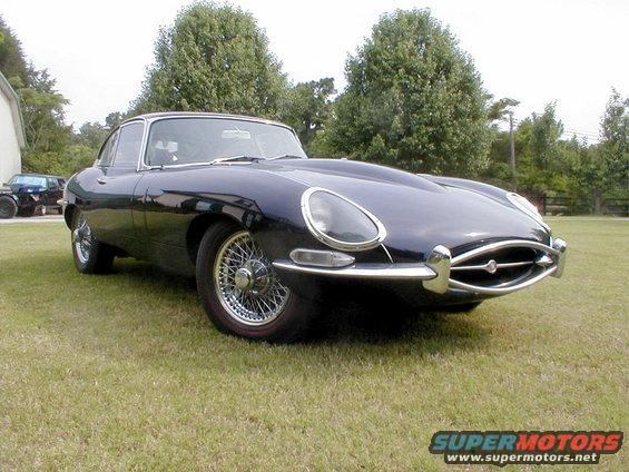 Dark blue 1967 Jaguar XKE coupe with wire wheels parked on grass