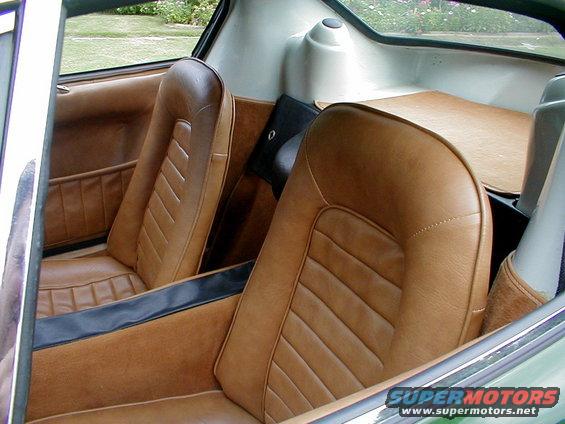 Interior view of a car showing tan bucket seats and door panels