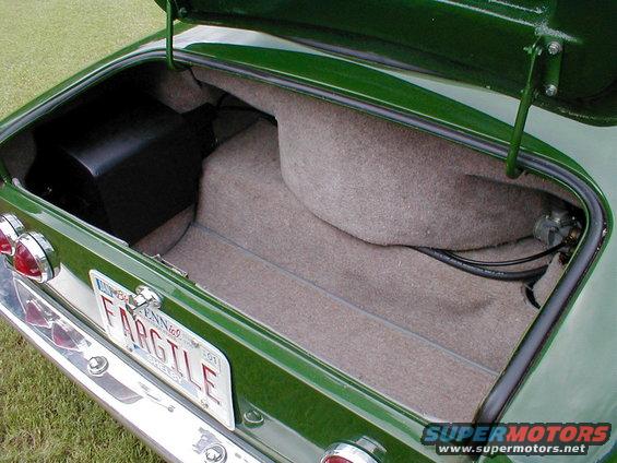 Green car trunk interior with spare tire well and license plate